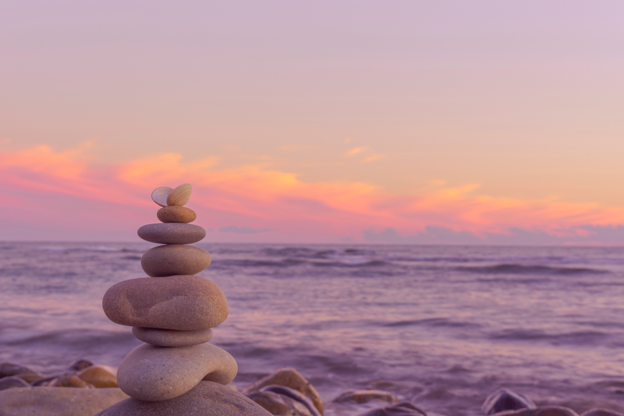 Balance of round pebbles on the background of a beautiful sunset.